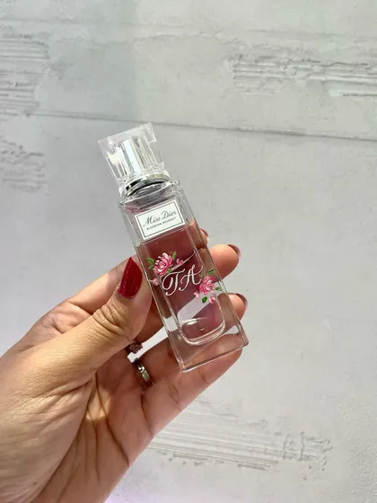 A hand-painted Miss Dior bottle, showcasing how floral artwork can be integrated with initials for a cohesive, personalized design.