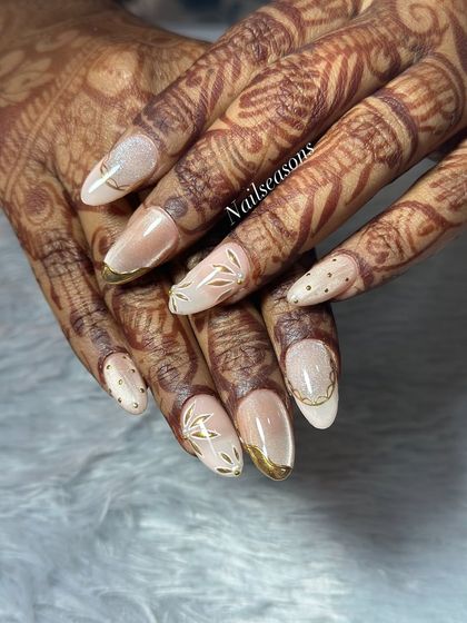 This angle shows how the different elements, from the gold-tipped French to the hand-painted leaves, come together to create a unique bridal design.
