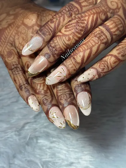 This angle shows how the different elements, from the gold-tipped French to the hand-painted leaves, come together to create a unique bridal design.
