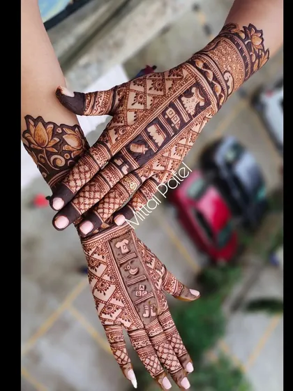 A full back hand design with a baby theme. The design features a vertical panel of baby items, framed by intricate jaali patterns and a lotus cuff.