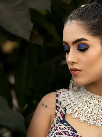 A bold and beautiful bridal portrait. The dramatic blue eye makeup and stunning diamond necklace are the focus of this captivating shot.