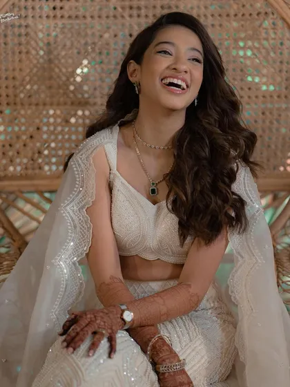 A happy, laughing bride enjoying her sangeet, her beautiful curls bouncing with her.
