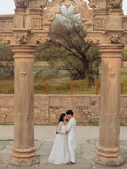Framed by historic pillars, this intimate moment feels like a scene from a classic romance. We use architectural elements to create depth and narrative in our pre-wedding photography.
