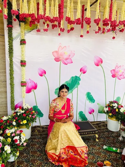 The bride seated for her Pellikuthuru rituals. Her pink and gold half saree is a beautiful choice for this ceremony.