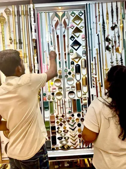Helping a client choose the right hardware. Here, we are looking at a vast selection of designer door handles to find the perfect match for their home's aesthetic.