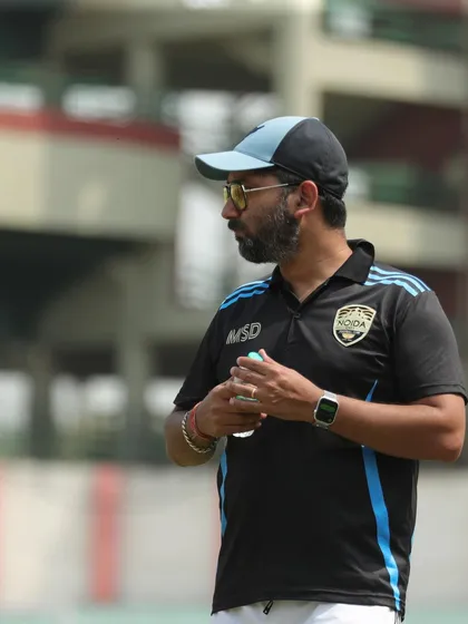 A candid shot of our coach on the sidelines, focused and strategic. This is the mind behind many of our victories.