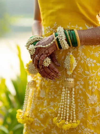 A detailed shot of our fresh flower hathphool and kaliras against a beautiful yellow dress.