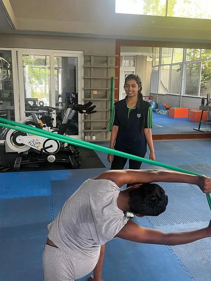 A female athlete works on mobility with a resistance band under the guidance of our passionate physiotherapy team. We ensure every player receives personalized care.
