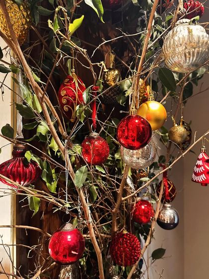 A creative way to display Christmas ornaments on bare branches, adding a rustic yet festive touch to your holiday decor.