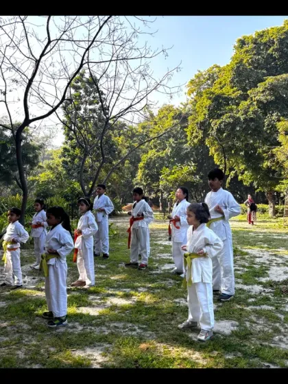 Students line up to perform their karate techniques in a park. Training in nature adds a different dimension to their practice.