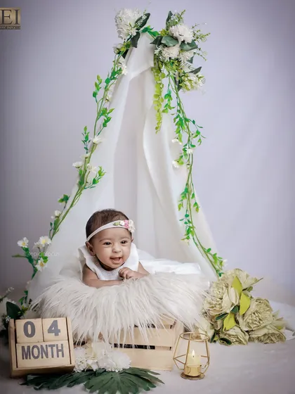 Celebrating four months with a beautiful floral teepee setup. This baby is at the perfect age for a "tummy time" pose, showing off her strength and happy smiles.