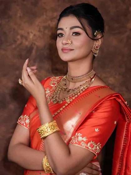 A graceful pose showing the intricate embroidery on the blouse and the elegant drape of the saree.