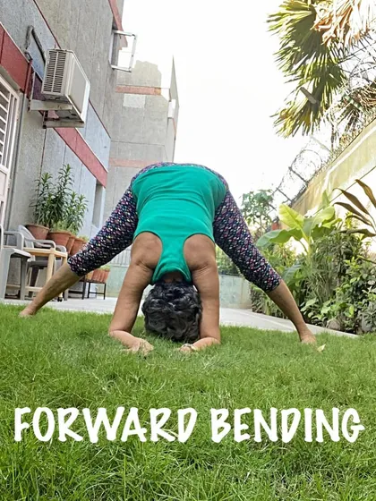 Practicing a wide-legged forward bend on the grass. The uneven surface adds a small balance challenge while enjoying the outdoors.