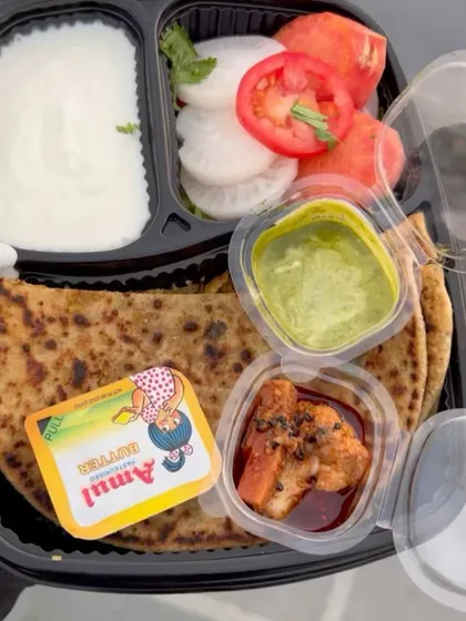 My popular Gobhi Paratha thali is a complete meal in itself. It features a generously stuffed paratha served with creamy dahi, a dollop of Amul butter, tangy pickle, and a fresh salad of tomato, cucumber, and onion.