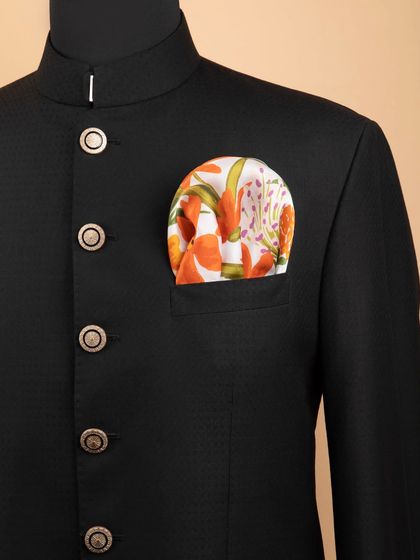 The bright orange floral pocket square adding a vibrant touch to a black jacket.