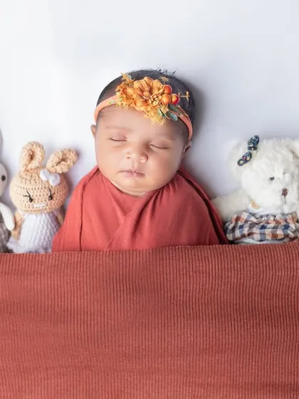 Tucked in and sleeping soundly with a lineup of adorable stuffed animal friends.