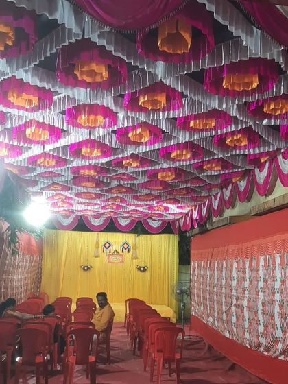 A wide view of a pandal setup for a Haldi ceremony, showing the decorated ceiling, stage, and seating arrangement.