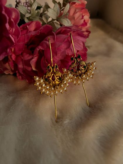 A close-up of our small peacock ear pins with pearl detailing. These are perfect for a simple, traditional look.