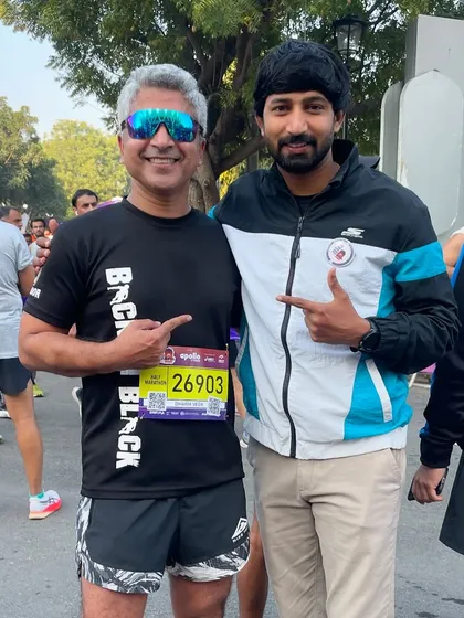 With a fellow runner, both pointing at each other in mutual respect. This is the camaraderie that defines the running world.