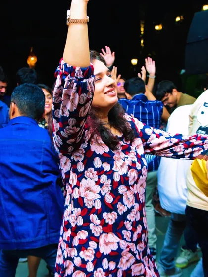 A partygoer with her hand in the air, completely immersed in the music and the moment.