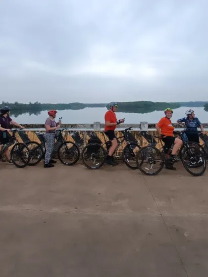 A group of our riders taking a photo break on a bridge over the calm backwaters. The West Coast ride is filled with picturesque landscapes, from lush forests to tranquil waterways.