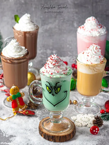 A fun lineup of Christmas-themed drinks, including a Grinch-inspired green shake. This shot is playful and perfect for showcasing a special holiday menu.