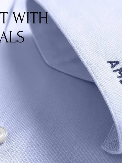 Personalize your handcrafted shirt with custom monogramming. This close-up shows initials embroidered on the cuff, a small detail that adds a significant touch of personal style to your business attire.