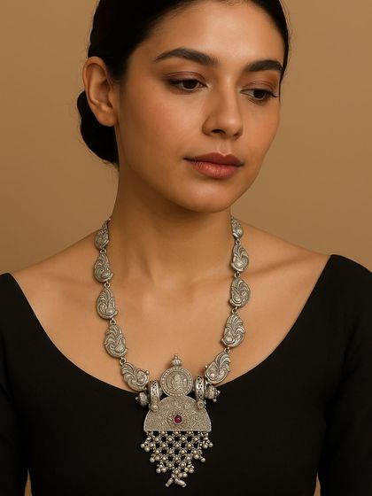 A model showcasing a premium pure silver necklace with an oxidised finish. The design features a temple-style pendant with intricate carvings and ghungroo drops.