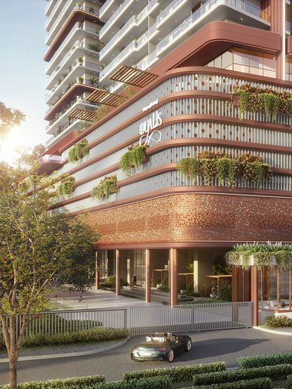 The entrance to The Dualis in Gurugram features a distinctive curved podium with integrated planters and a perforated metal screen. This design creates a grand sense of arrival while softening the building's facade with layers of greenery.