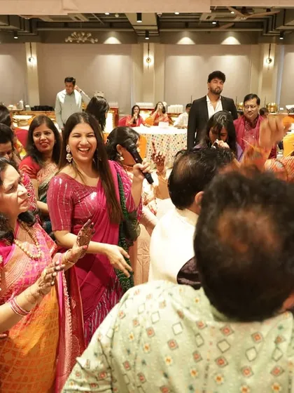 Another shot of the joyful celebration. The room is filled with smiles, dance, and the vibrant colors of traditional attire.