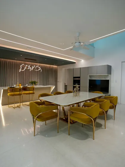 The dry kitchen in the Reddys' home is a glamorous space for entertaining, with an elegant dining set, a stylish island, and dramatic lighting.