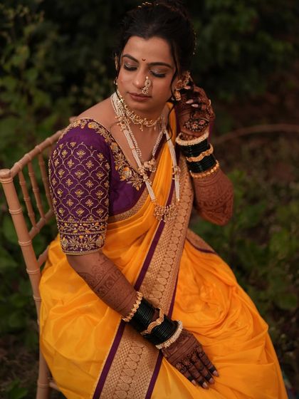 A beautiful bride enjoying a quiet moment. The deep brown stain of her henna on her hands and arms looks so elegant against her yellow and purple saree.