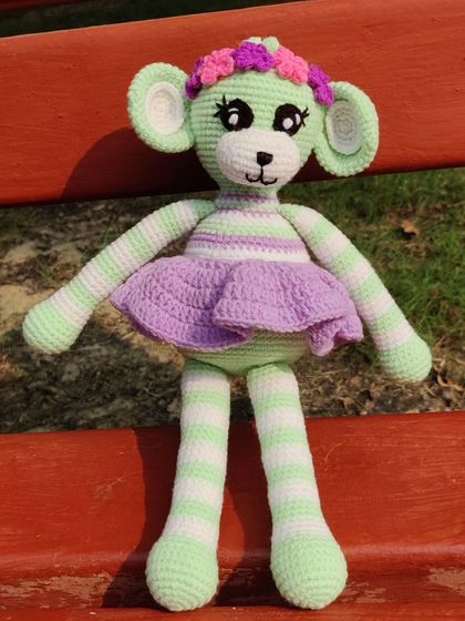 This adorable monkey doll in pastel green and purple, complete with a flower crown.