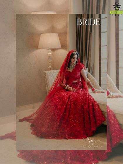A portrait of the beautiful bride in her radiant red lehenga, captured in a quiet moment before the ceremony begins.