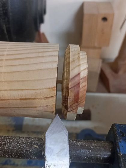 Parting off the lid from the main body of the box on the lathe. This is a delicate operation that requires a steady hand.