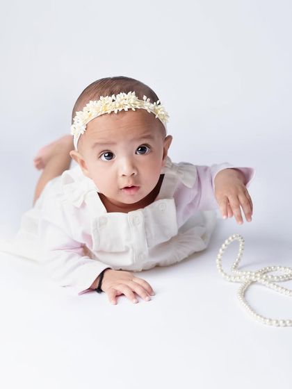 I'm always in love with these classic shots. A simple white background, a string of pearls, and an adorable baby are all you need for a beautiful, timeless portrait.