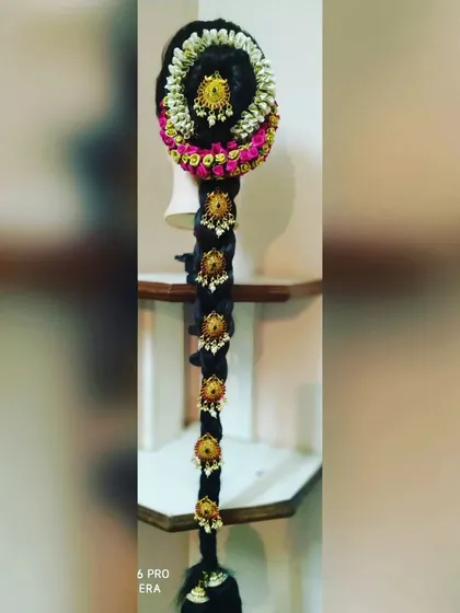 This is an example of a traditional South Indian bridal jada. I create these intricate hairstyles using extensions, fresh flowers, and traditional hair ornaments to achieve a classic and authentic muhurtham look.