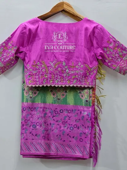 A full view of the back of the embroidered magenta blouse.