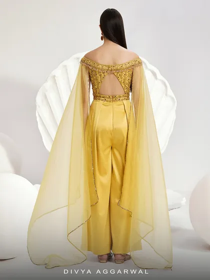 The back of the Emma Jumpsuit, revealing the open-back design and the full, flowing expanse of the organza cape sleeves.