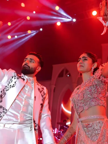 Dancing the night away under the vibrant stage lights. This image captures the high energy and fun of the Sangeet party.