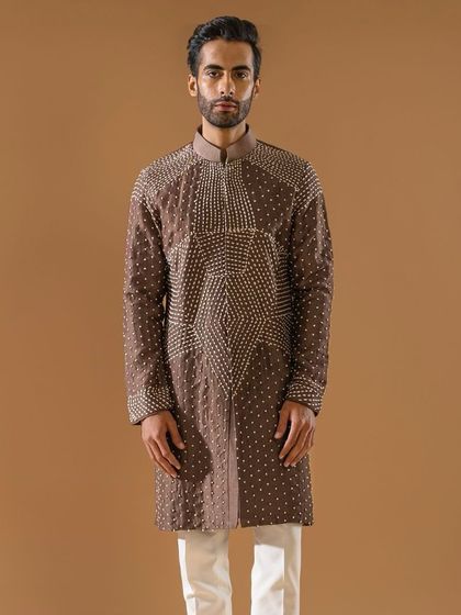 A brown kurta adorned with intricate geometric patterns in shimmering threadwork. This piece is part of our elusive and alluring Indian wear, blending craftsmanship with flattering silhouettes.