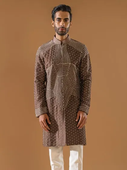 A brown kurta adorned with intricate geometric patterns in shimmering threadwork. This piece is part of our elusive and alluring Indian wear, blending craftsmanship with flattering silhouettes.