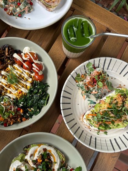An overhead shot of a perfect brunch spread. Our nourish bowl, avocado toast, and an iced matcha make for a balanced and delicious meal.