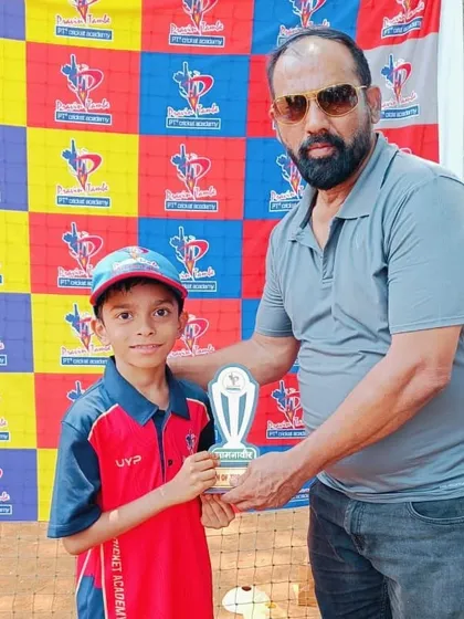 An U-10 player in his red and blue kit receives the Man of the Match award for his excellent game.