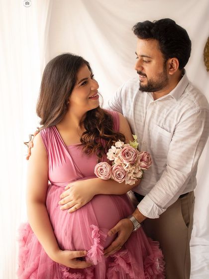 An intimate couple's portrait, capturing the shared happiness and anticipation. The soft pink gown adds a touch of romance.