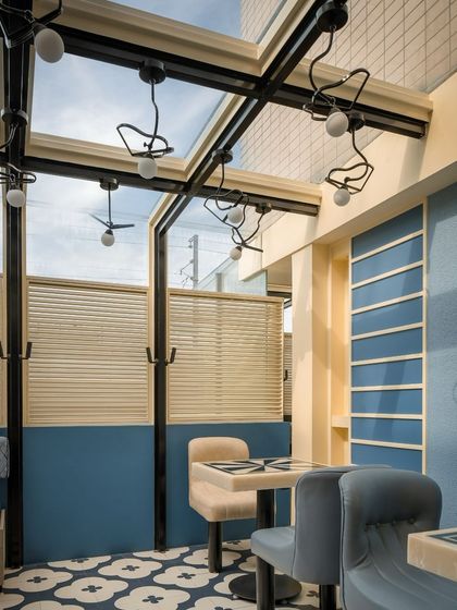 In contrast to the vibrant red zones, we designed this calmer blue section at Masala. The space features a glass ceiling and custom bird-like light fixtures, creating an airy, conservatory-like feel for daytime dining.