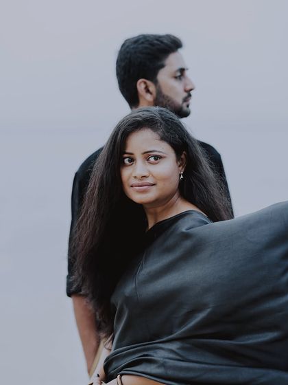 A striking portrait from a pre-wedding shoot, where the woman looks at the camera while her partner stands behind her.