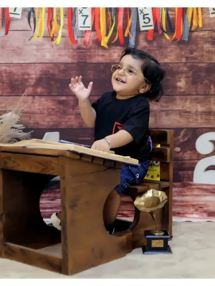 Back to school! This creative theme with a miniature wooden school desk and glasses is a fun way to capture a studious and playful look.