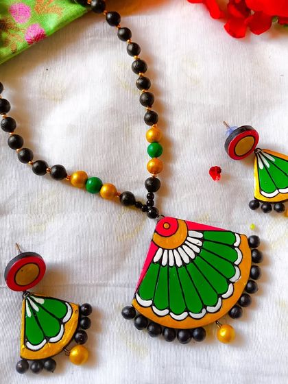 A simple and elegant fan-shaped pendant necklace in green and pink, perfect for the Sawan season or Independence Day.