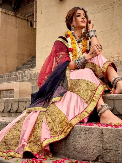 A serene moment from a festive campaign, with the model seated on ancient steps. The styling combines a traditional lehenga with heavy silver anklets and bangles, creating a look that feels both regal and grounded.